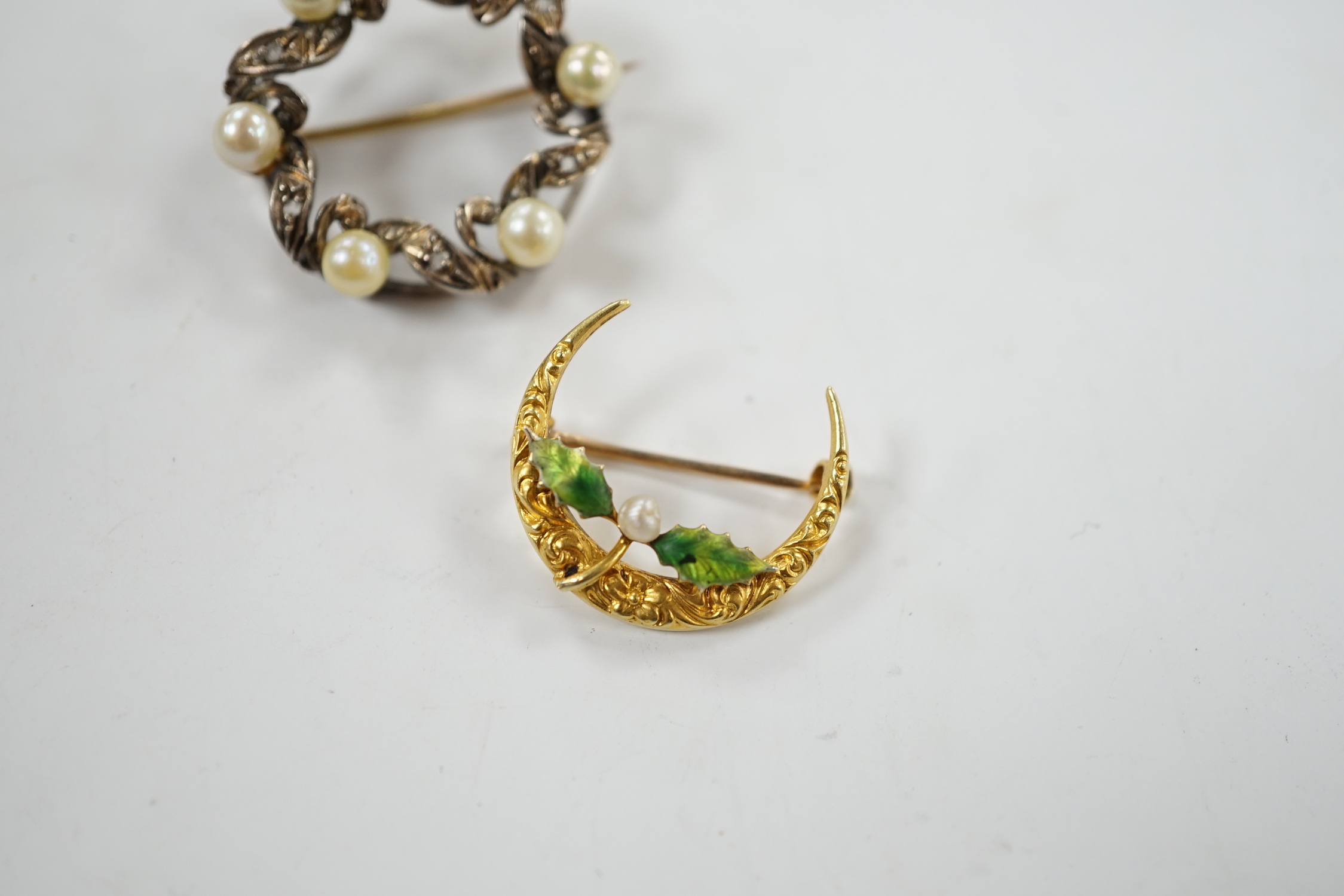 A yellow metal enamel and small baroque pearl set folate crescent brooch, 27mm, together with a yellow metal, cultured pearl and diamond chip set openwork circular brooch.